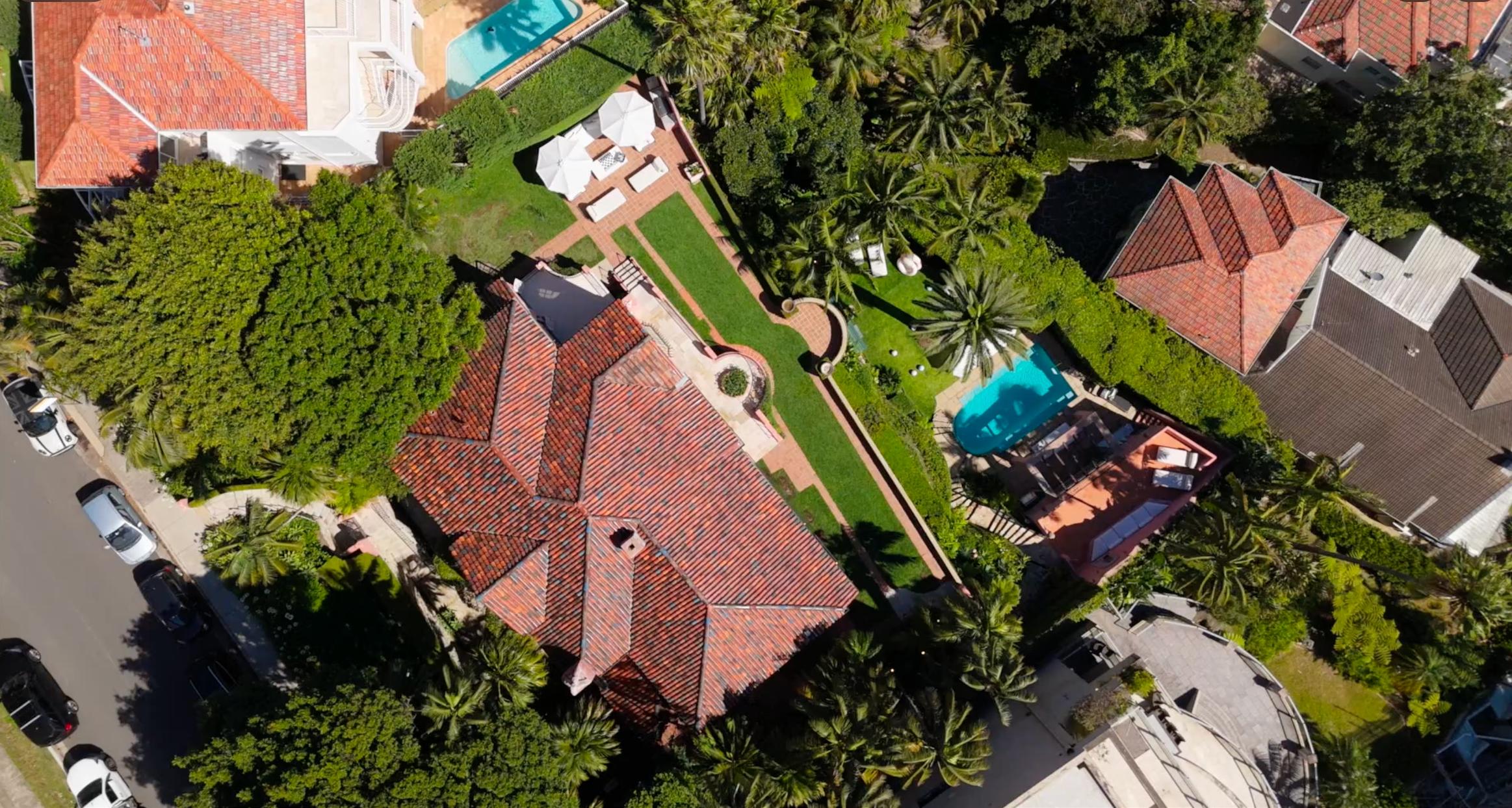 Aerial drone view directly above Villa Biscaya showing terracotta roof, brick paths and lush gardens