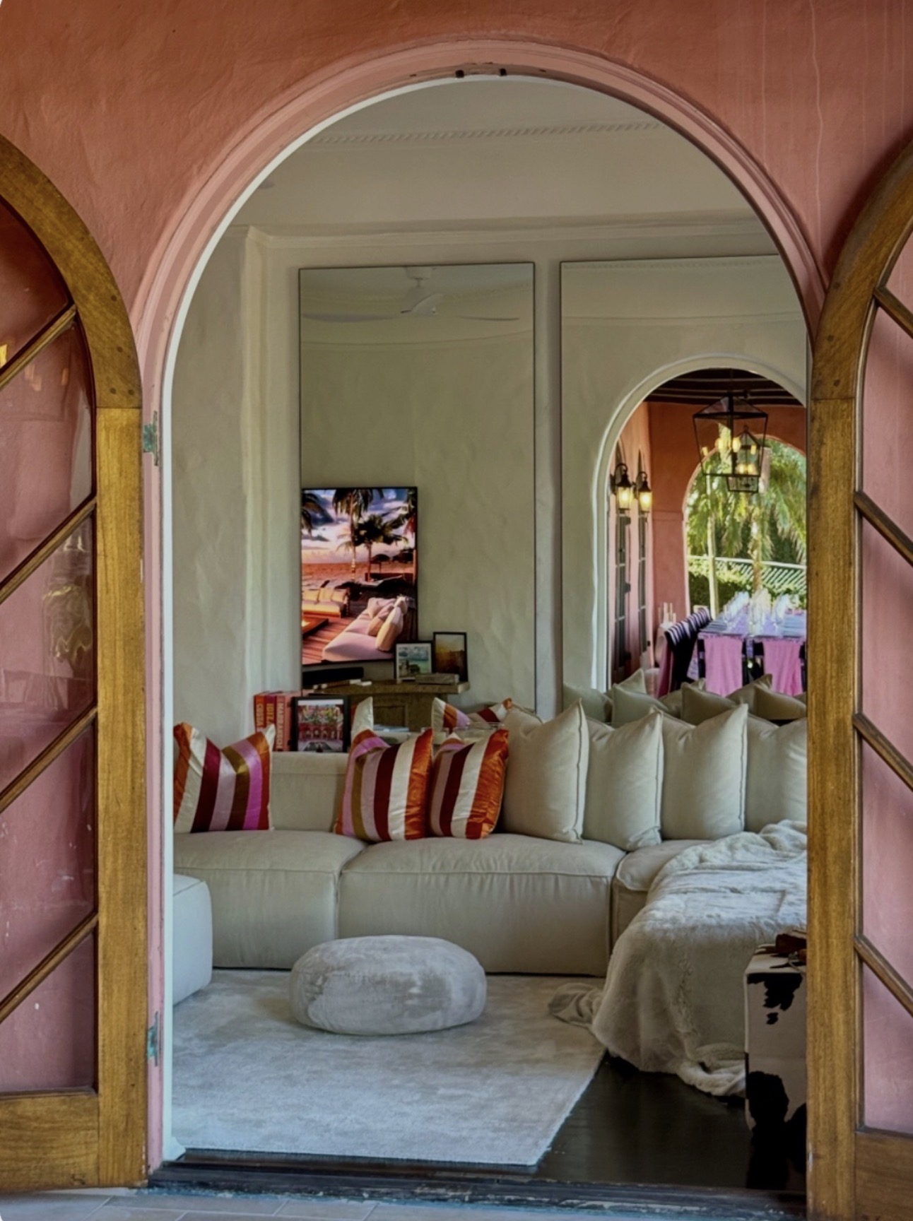 Lounge room through pink arch with striped pillows and sectional sofa